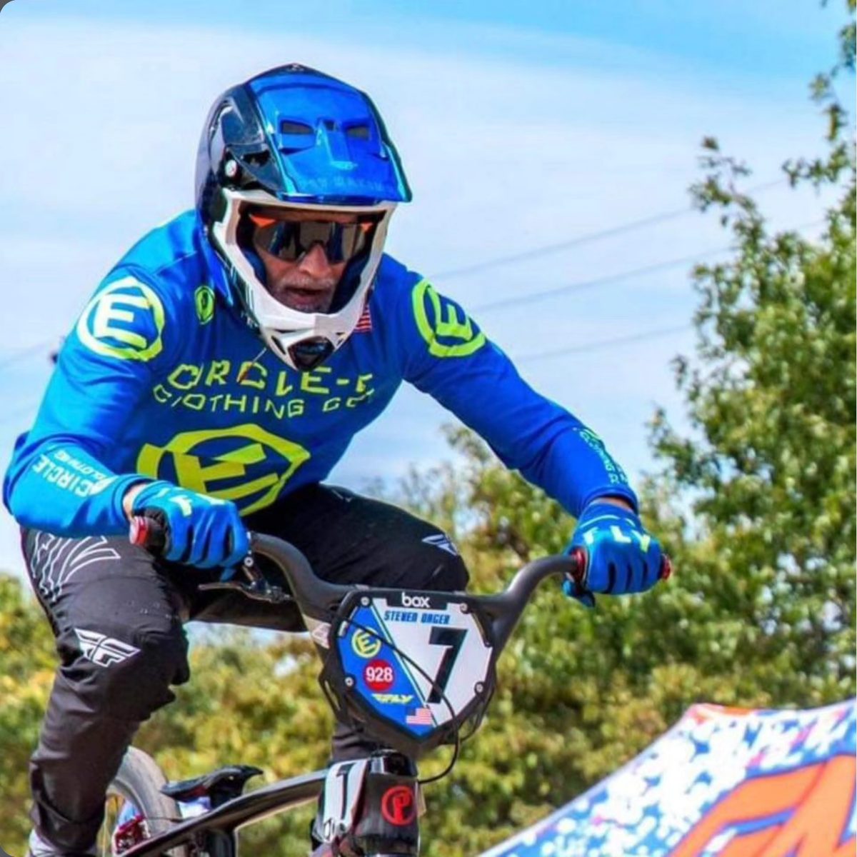 Rider in a Circle-E jersey airborne over a jump